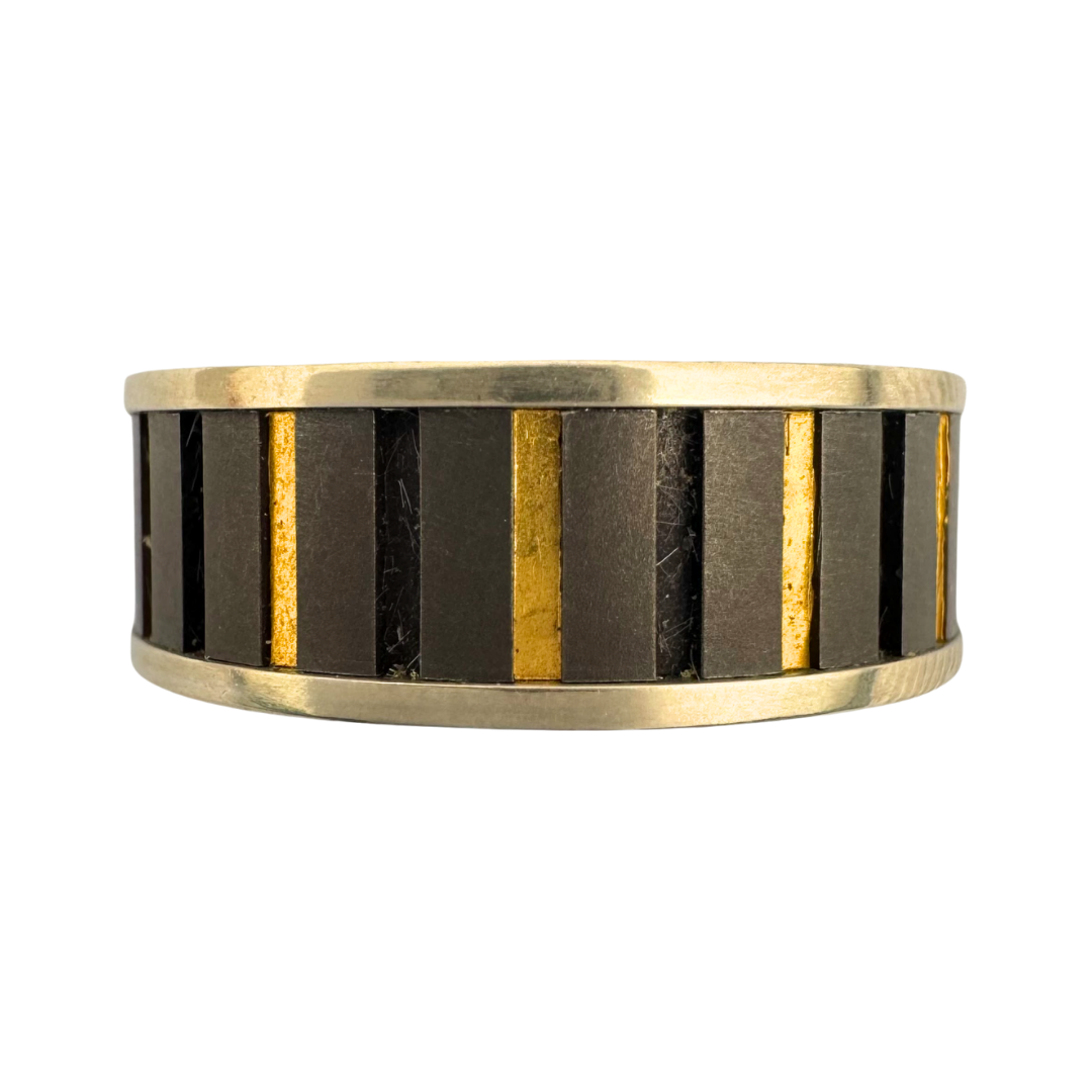 Titanium band with white gold shoulders and vertical grooves alternately inlaid with 24K gold
