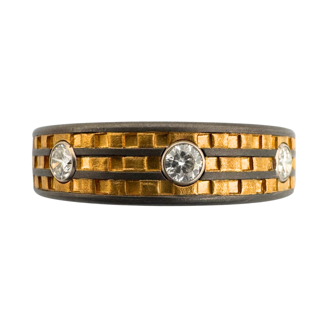 Titanium band with (3) channels of gold punch work and set with (8) 2.5mm diamonds in gold settings