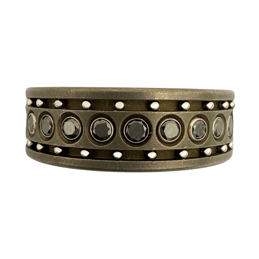 Titanium band with (24) black diamonds set in 14K white gold with outer channels of stainless steel balls