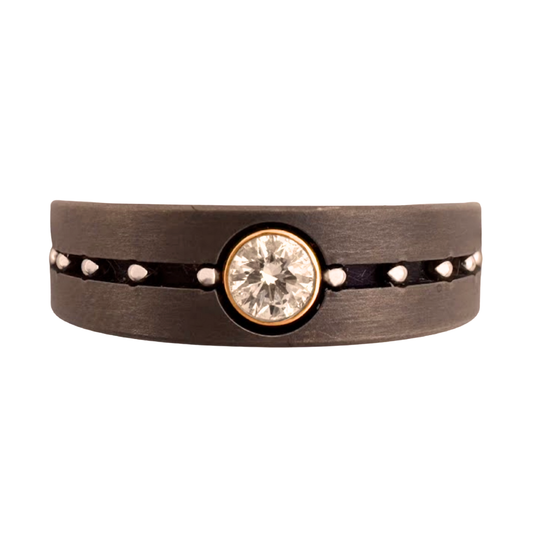 Titanium band with center channel with stainless balls, set with 3mm diamond in 14K white gold, enhanced by a dark background for the stainless balls and diamond