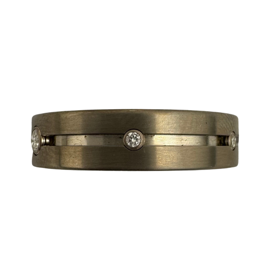 Titanium band with (5)1.5mm diamonds and (1)2.5mm diamond in 14K gold settings on the center channel
